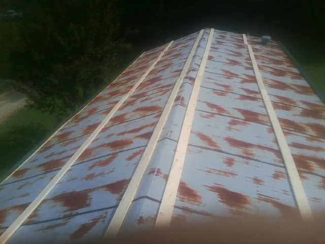 Rusted metal roof panels with new wood purlins before replacement — Storm Damage Roof Repair in Blytheville by Roofing Brothers