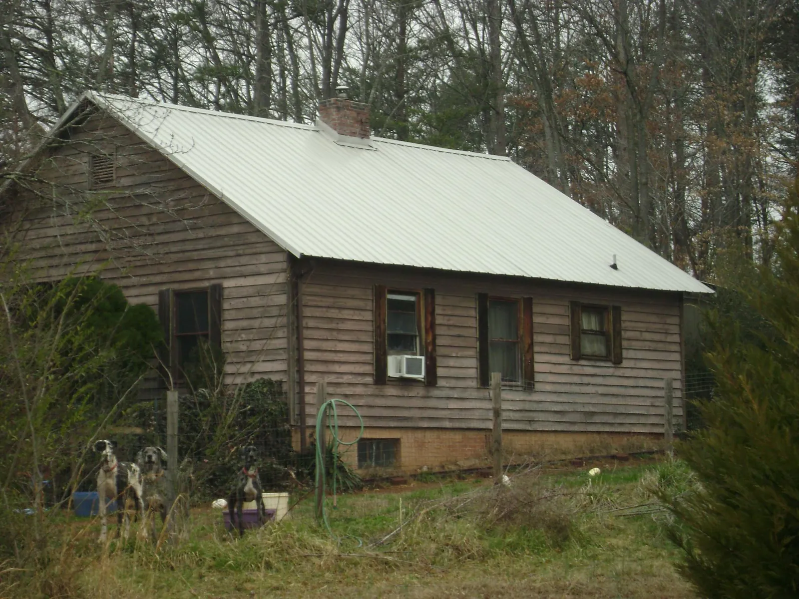 White metal roof on an old wood sided farmhouse, from a Metal Roof Installation job in Blytheville